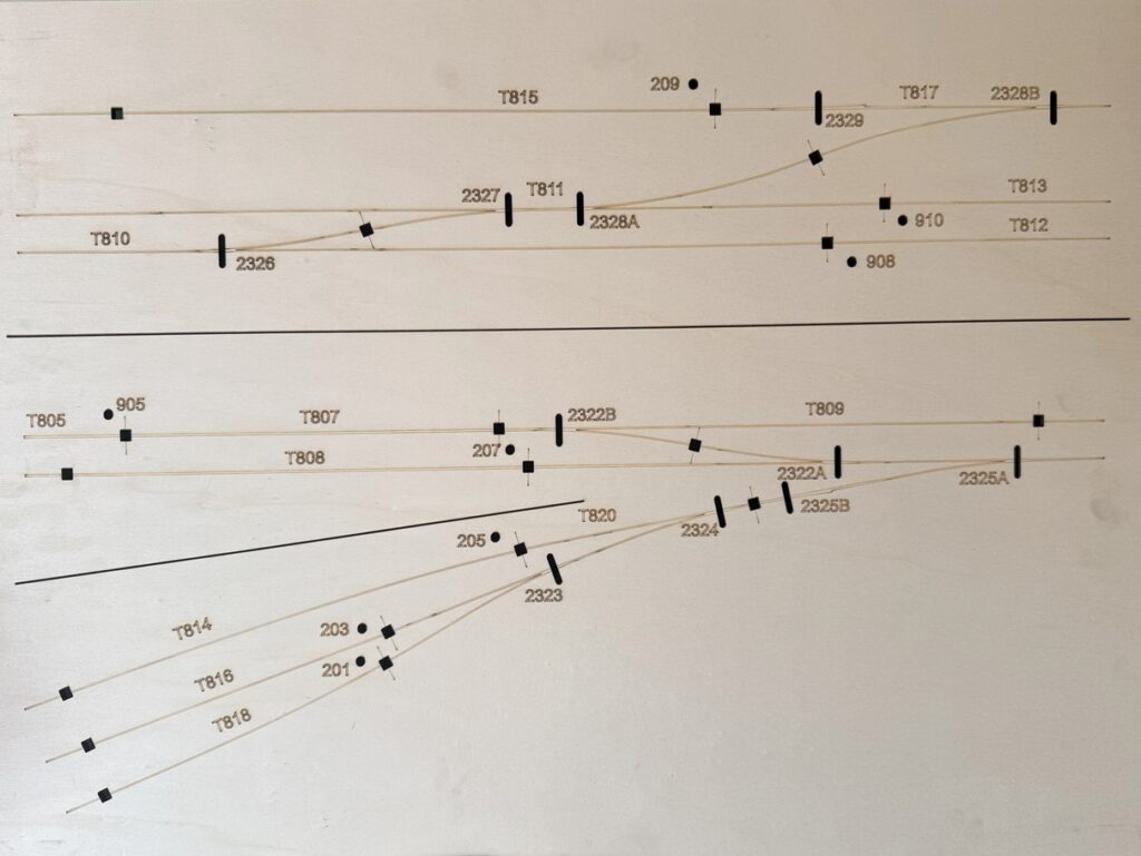 A laser cut model railway baseboard, with engraving to show the track position and holes for the wiring.