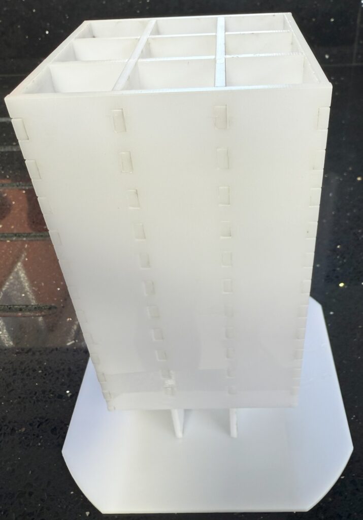 A laser cut acrylic Oxo cube stacker with eight columns of cubes.