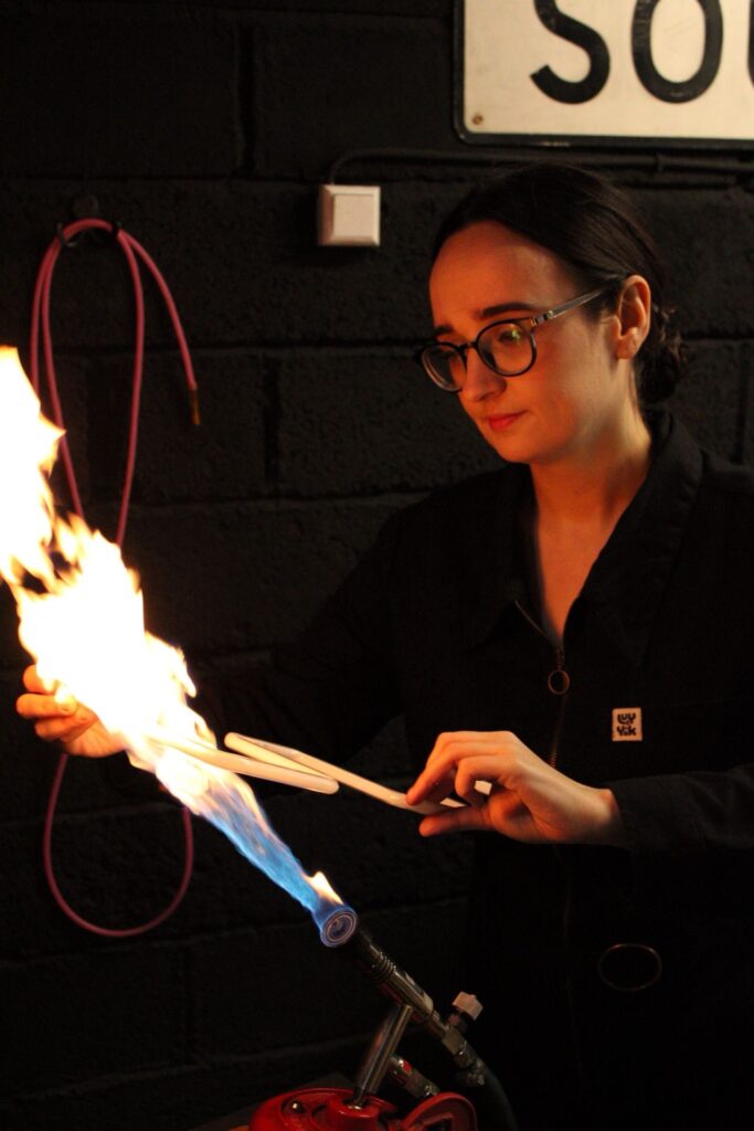 Amy bending some neon in a bright flame.